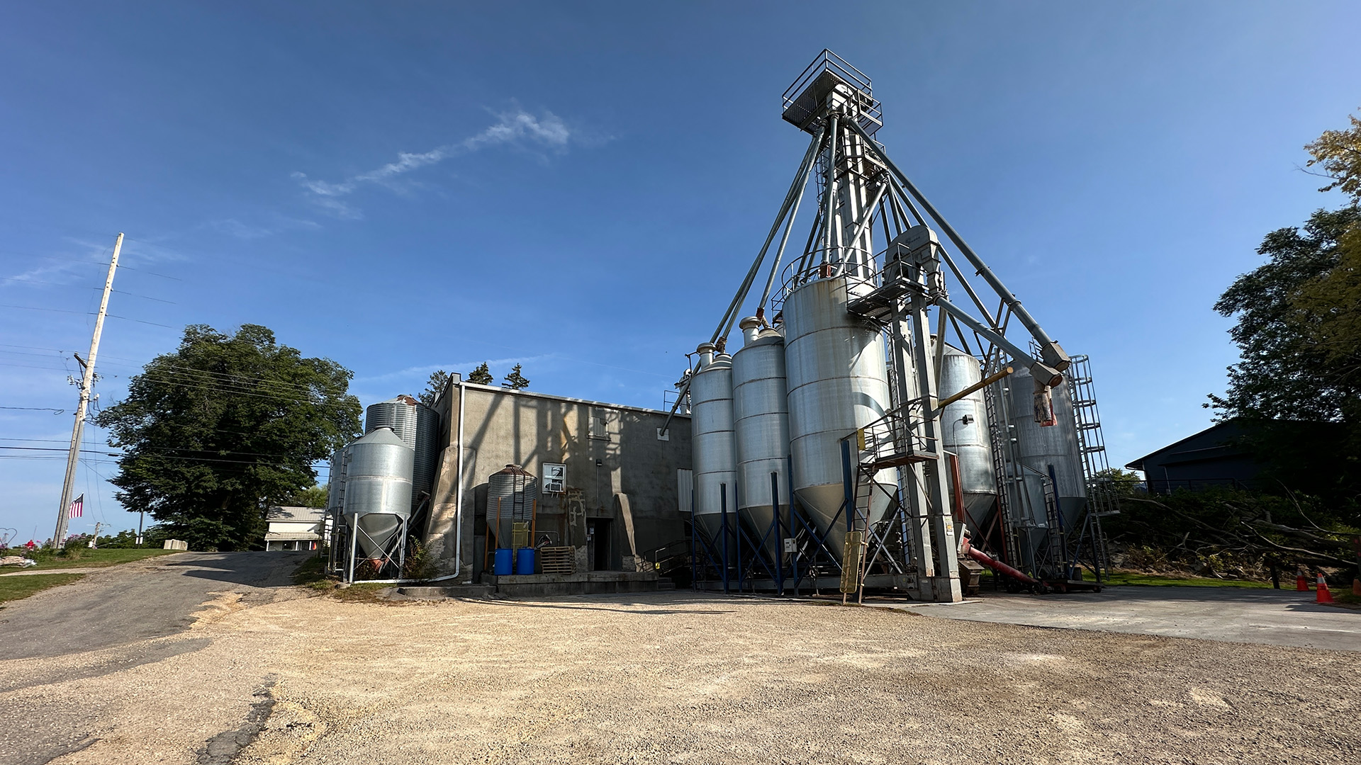External food production plant with clear blue skies on dirt road
