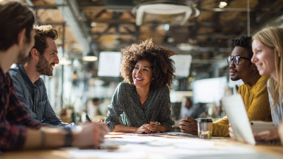 Business team discussing a blend and extend lease at a table in an open, industrial-style office