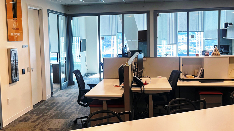 Interior image at The Bridge showing some workstations with a conference room in the background