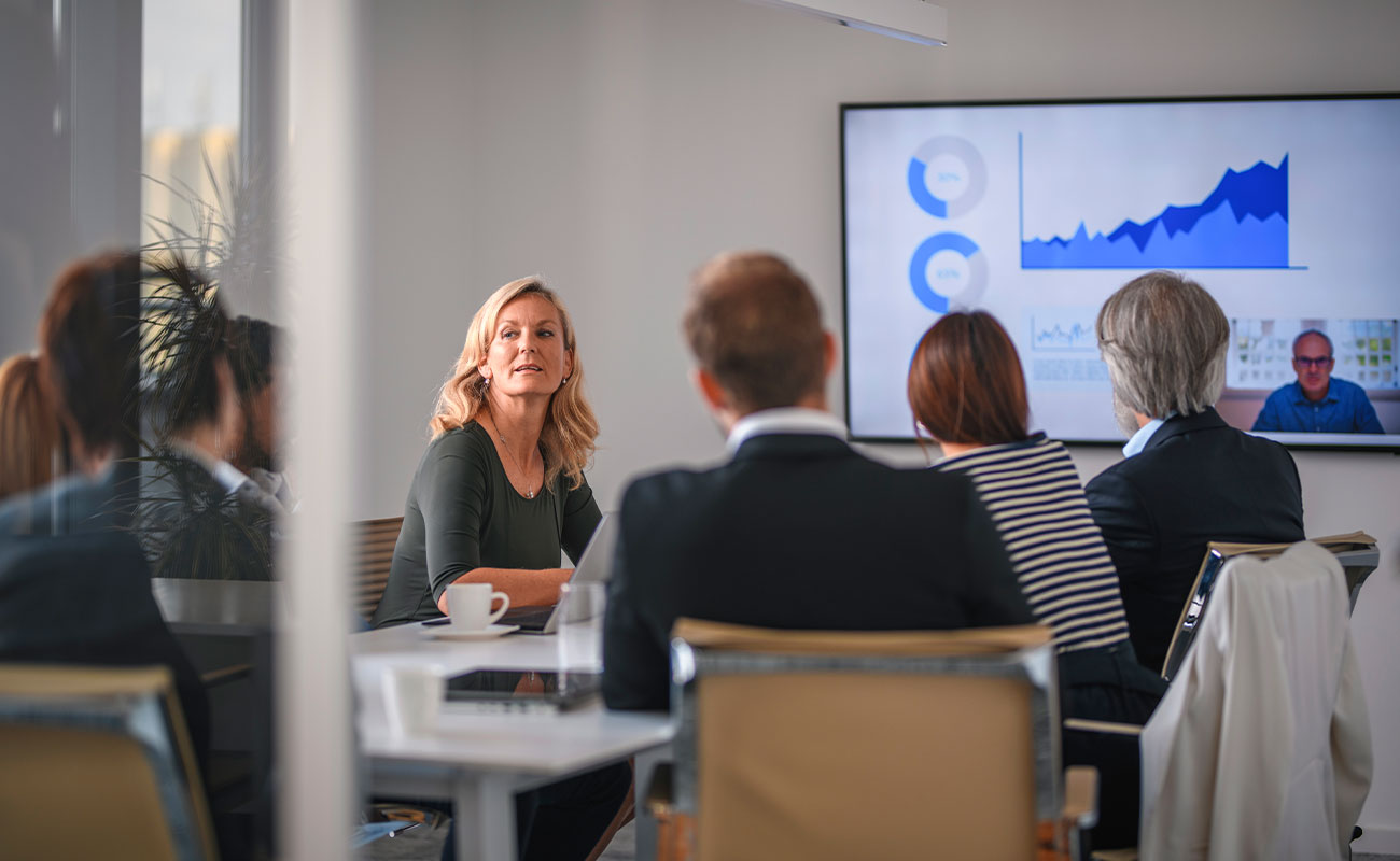 People sitting around a conference table with analyitics